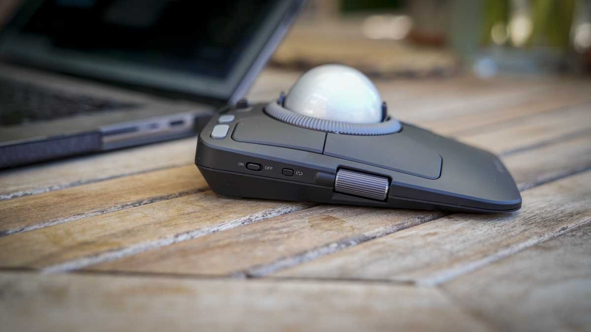 A side view of the Kensington TB900 beside a laptop, showing the ball, surrounding ring and side controls. Image: Alastair Jennings / Future.
