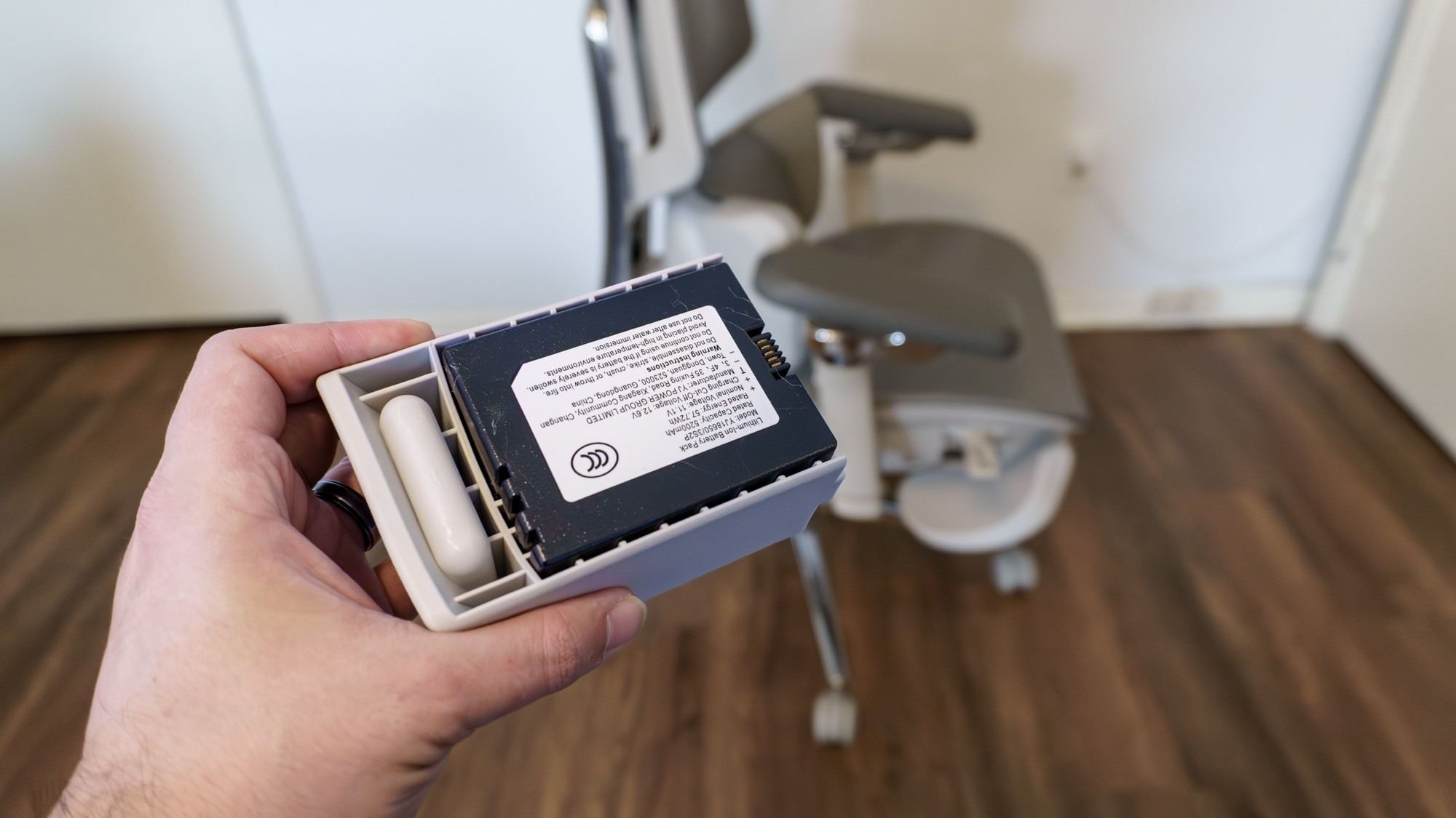 The removable Hbada X7 battery held in front of the chair during the review. Image: Future.