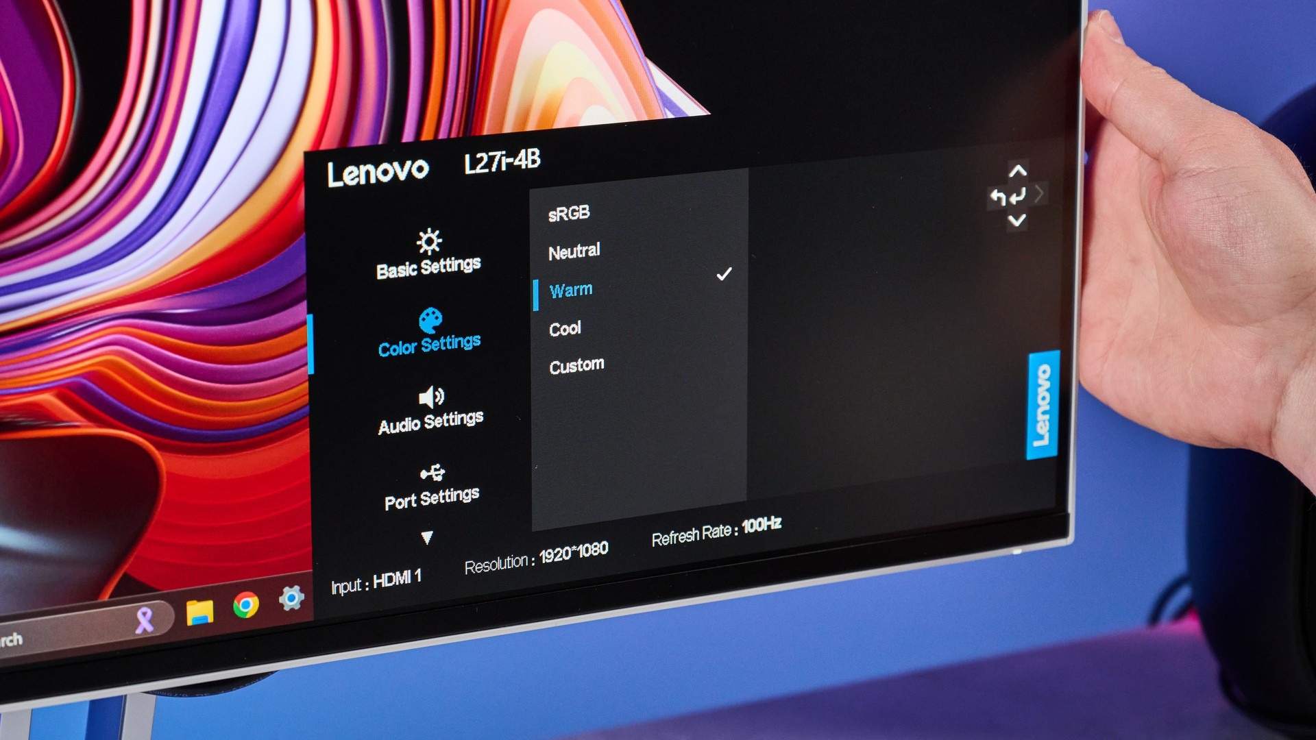 The Lenovo L27i-4B's on-screen settings menu open while a hand reaches behind the panel to operate its controls. Image: Tom's Guide.