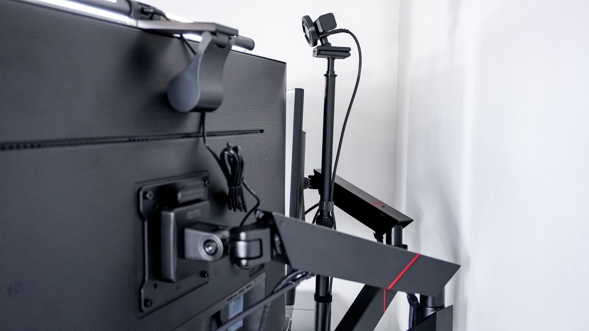 A rear view of the independently supported webcam and its cable behind the dual-monitor setup. Image: Tom's Guide.