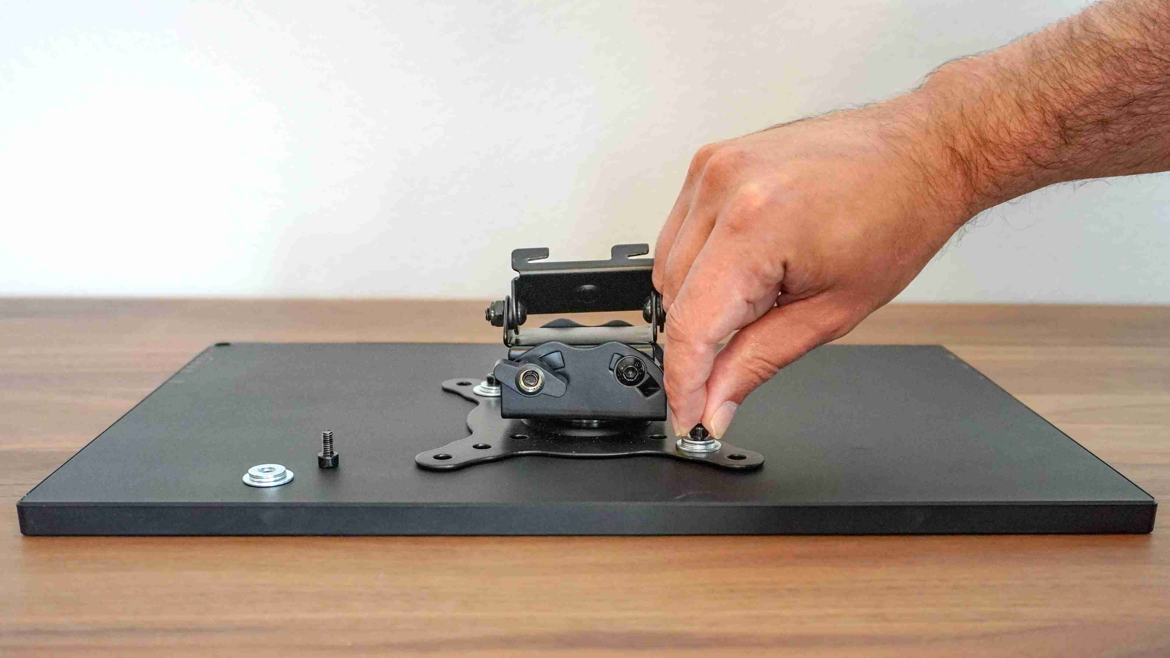 A mounting plate being fitted to the portable monitor before installation beside the ultrawide. Image: Tom's Guide.