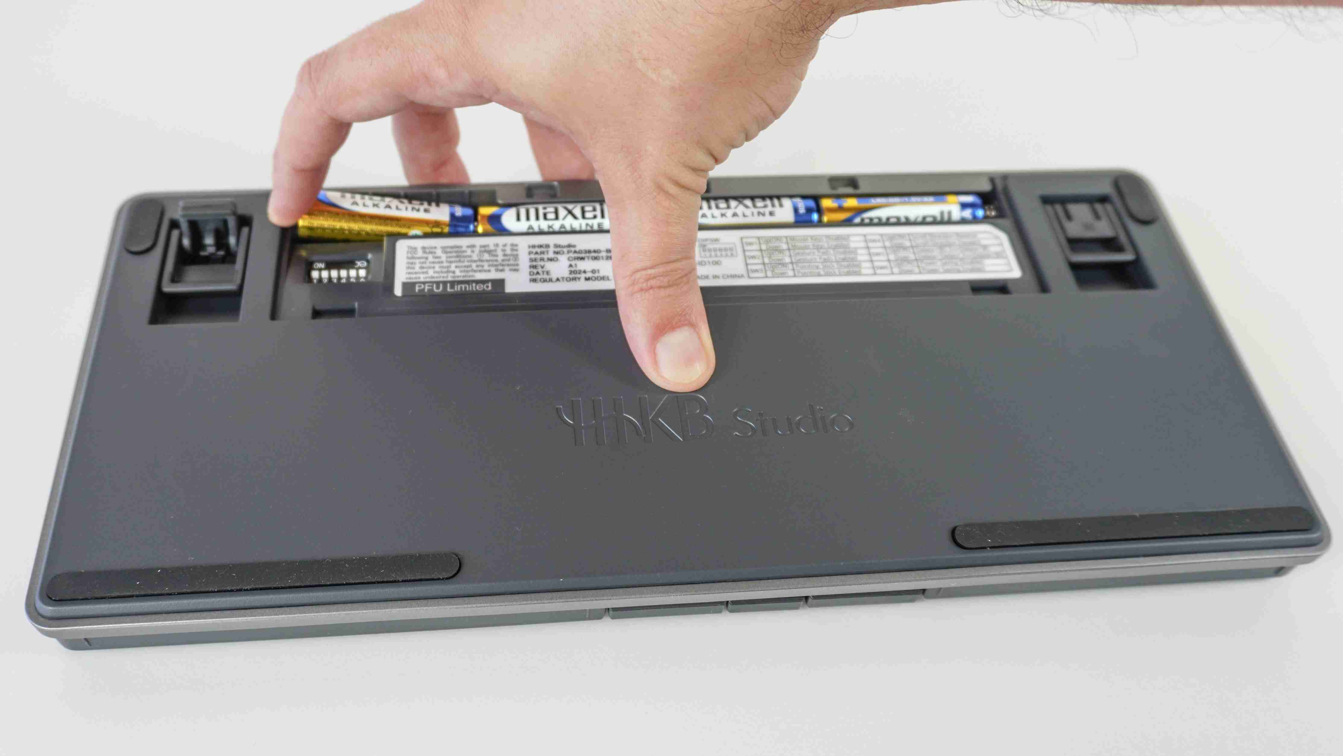 The HHKB Studio battery compartment with replaceable AA batteries being installed. Image: Anthony Spadafora / Future.