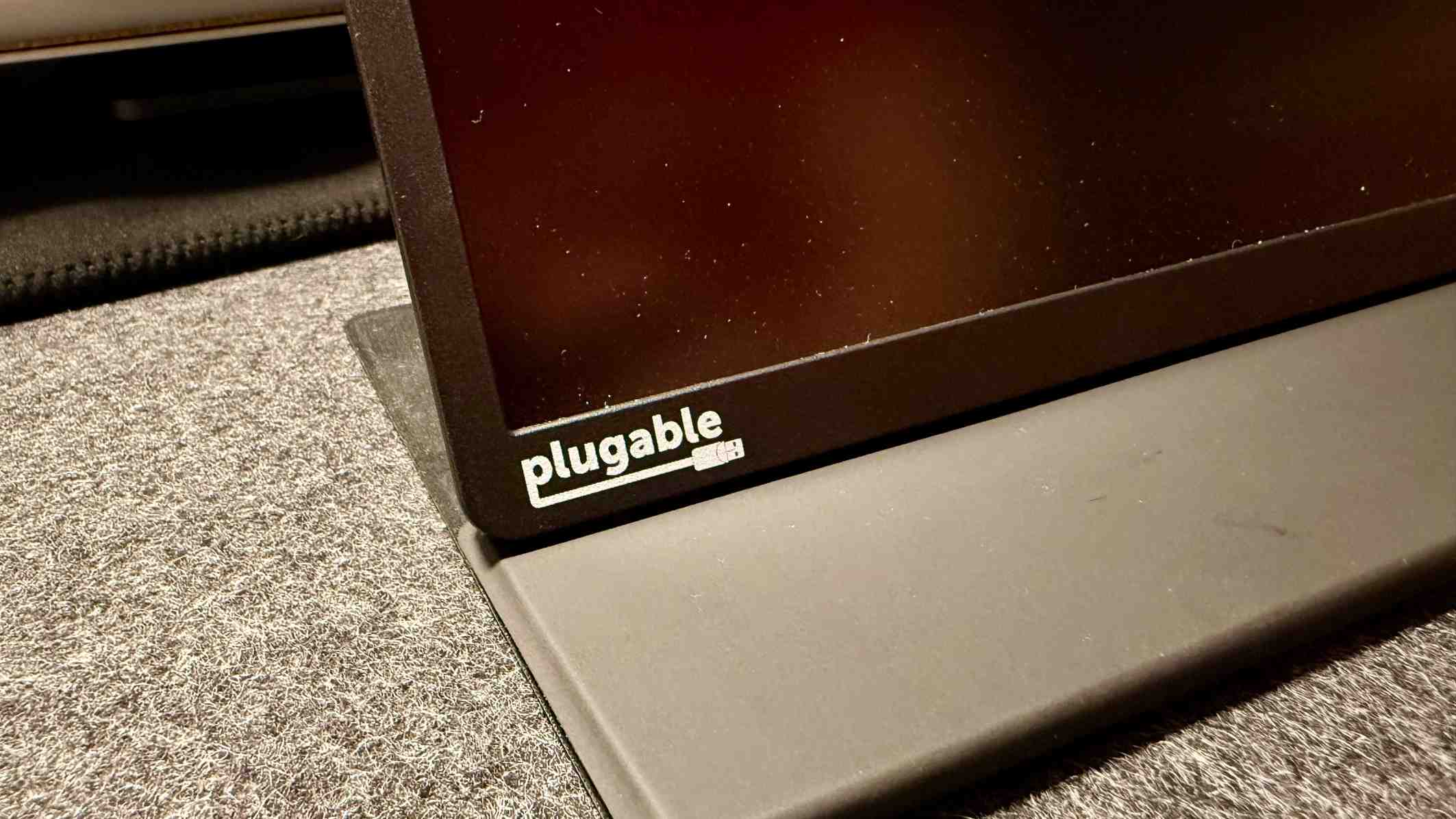 The lower edge of the Plugable portable monitor resting against its folio support. Image: Collin Probst / Future.