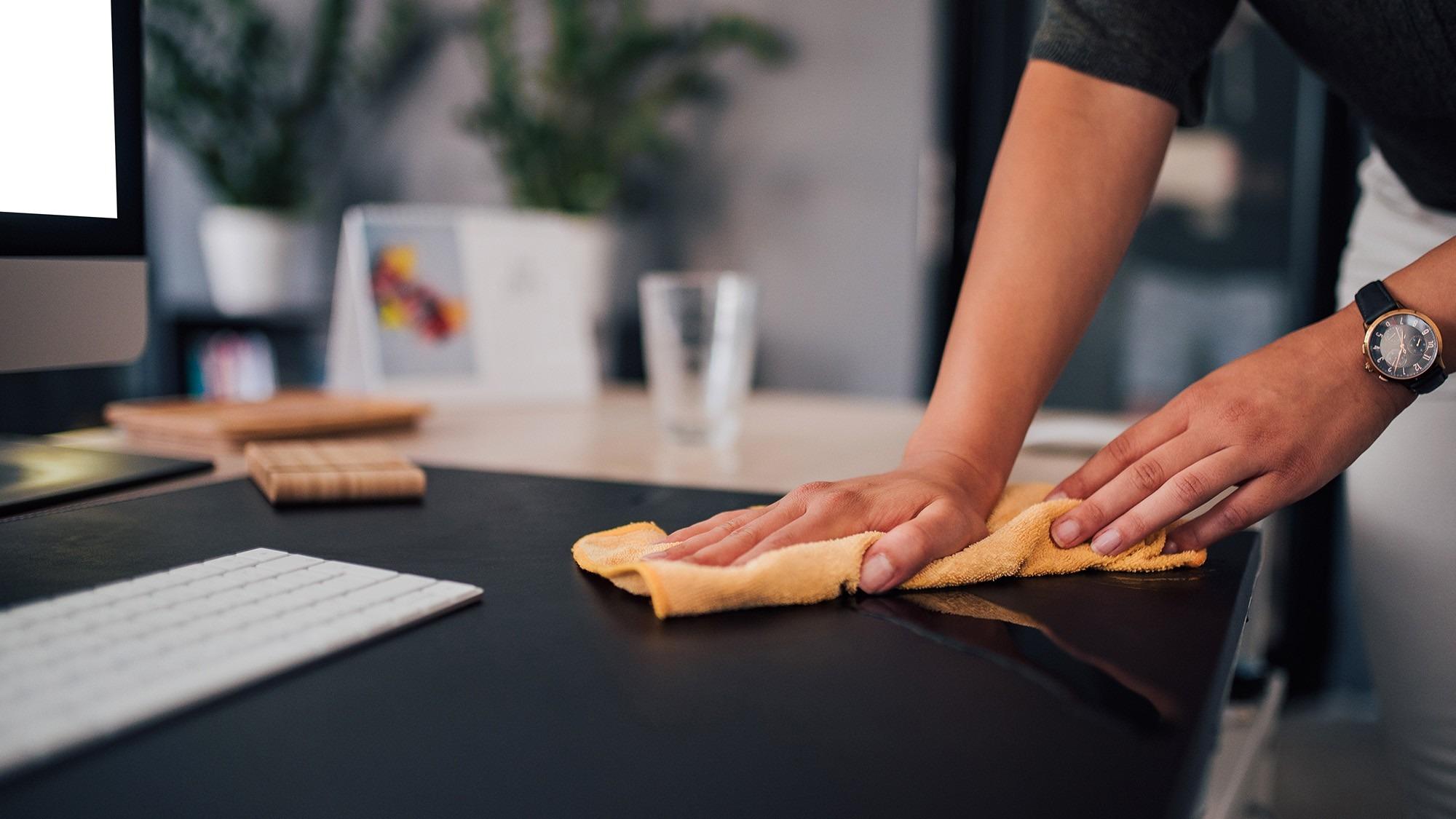 A separate illustrative photograph of a desktop being wiped, supplied with the source feature. Image: Tom's Guide.
