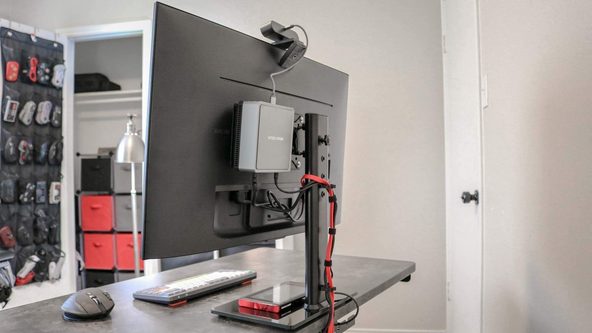A rear view of a supported monitor with a mini PC mounted behind it, illustrating equipment and cable space around the support. Image: Tom's Guide.