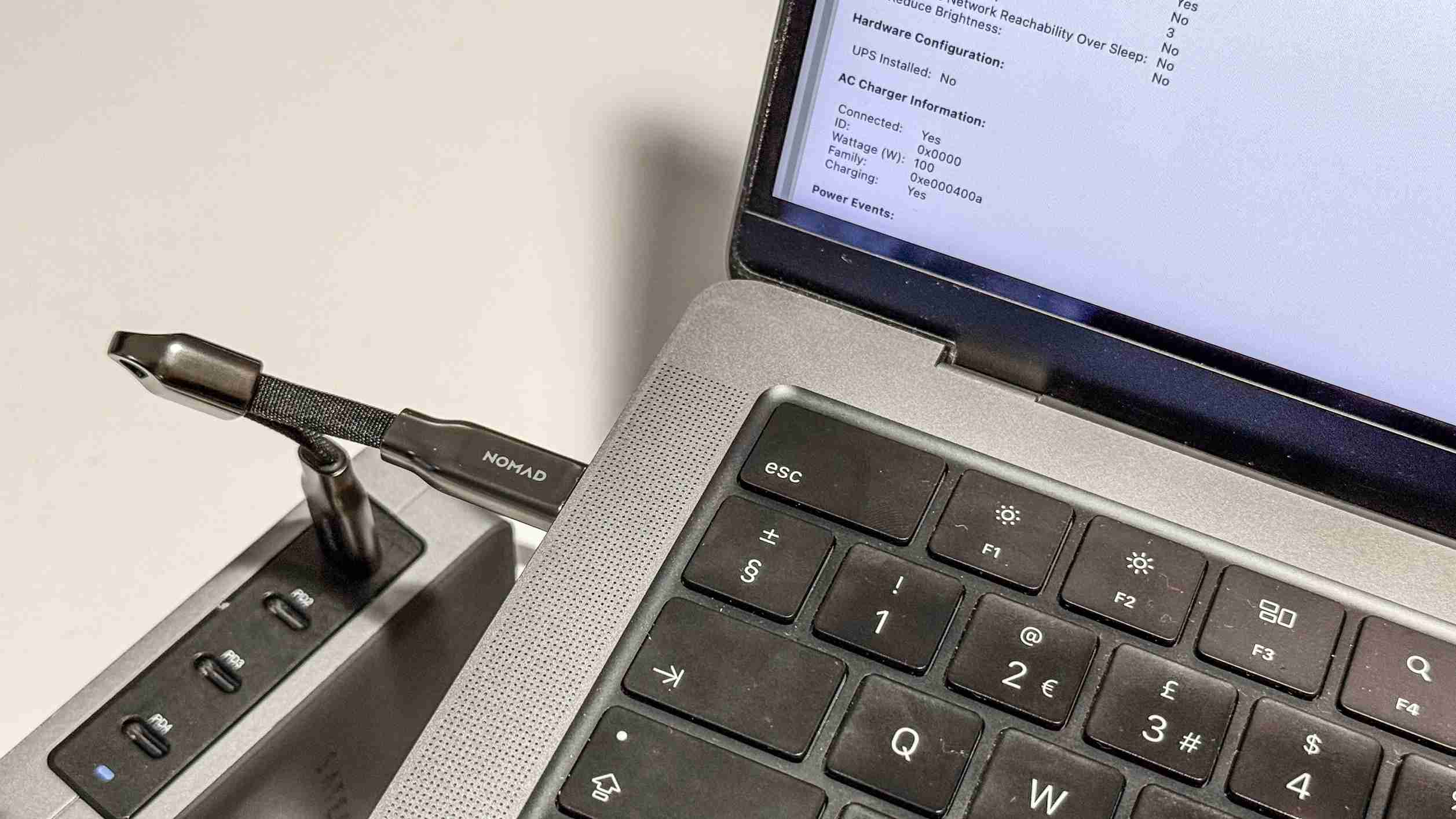 The short Nomad ChargeKey connected to a MacBook beside a power adapter. Image: Future.