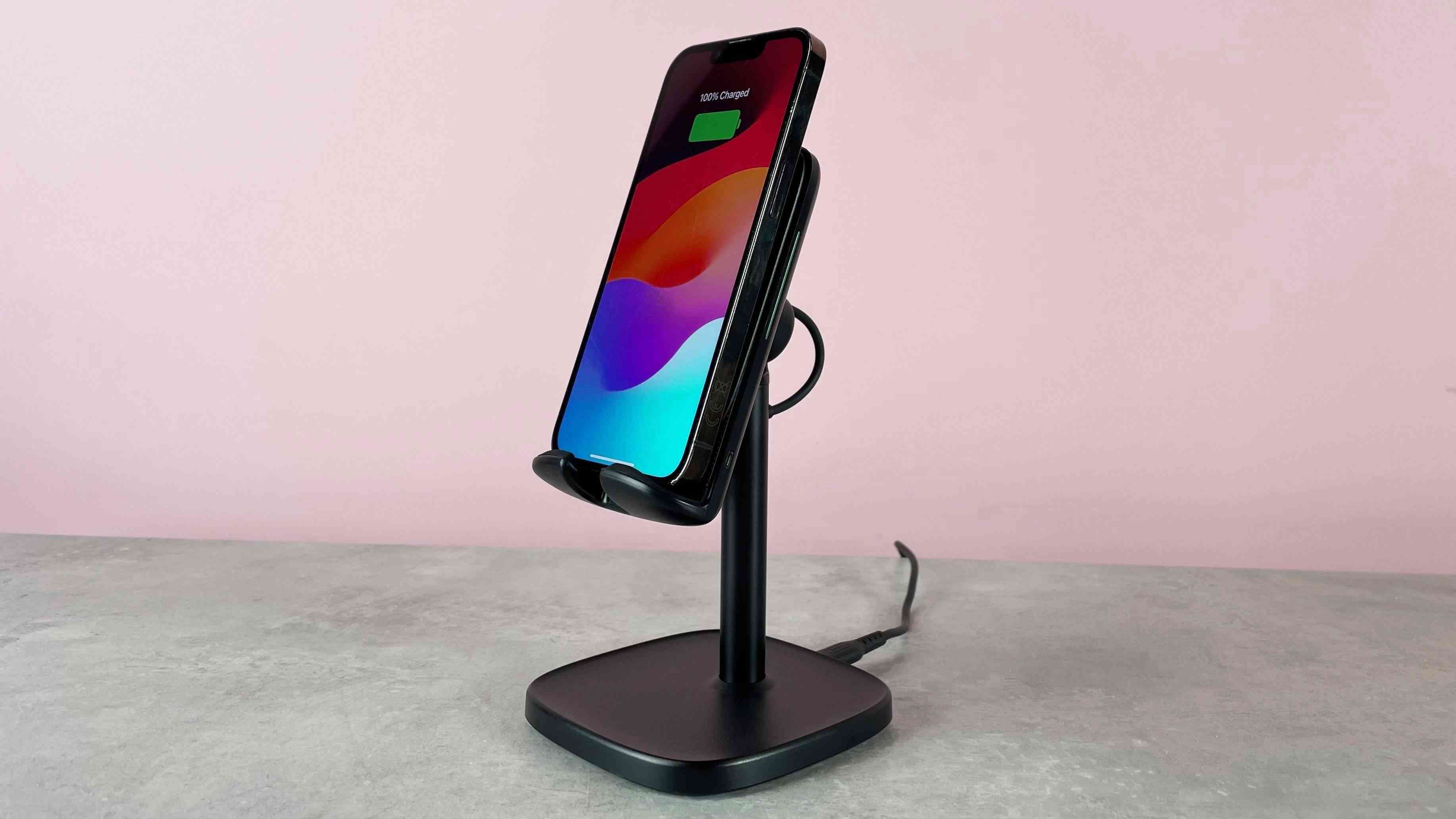 An iPhone resting upright on the INIU I212 charging cradle against the review background. Image: Future.
