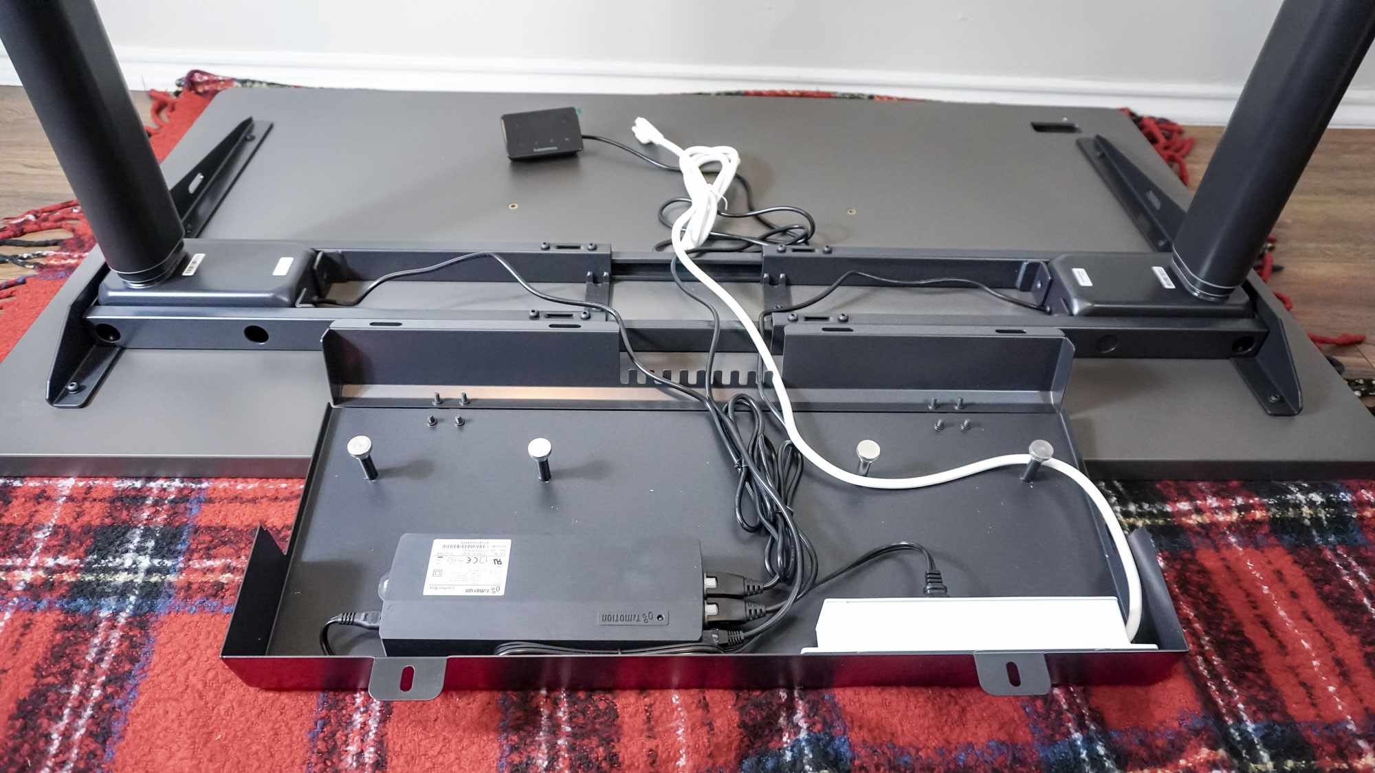 The underside of the Autonomous SmartDesk 5 with the cable compartment open and the equipment leads arranged inside. Image: Future.
